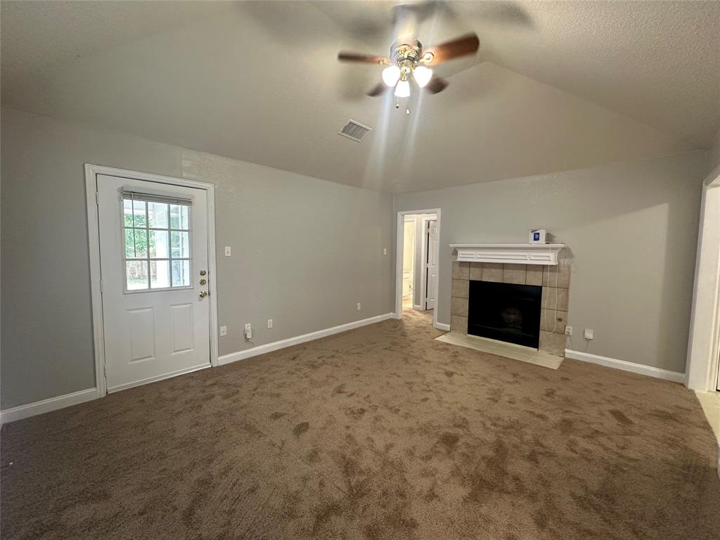 4147 Gladewater Road Dallas, TX 75216 - Photo 5 of 31 an empty room with a fireplace and fan