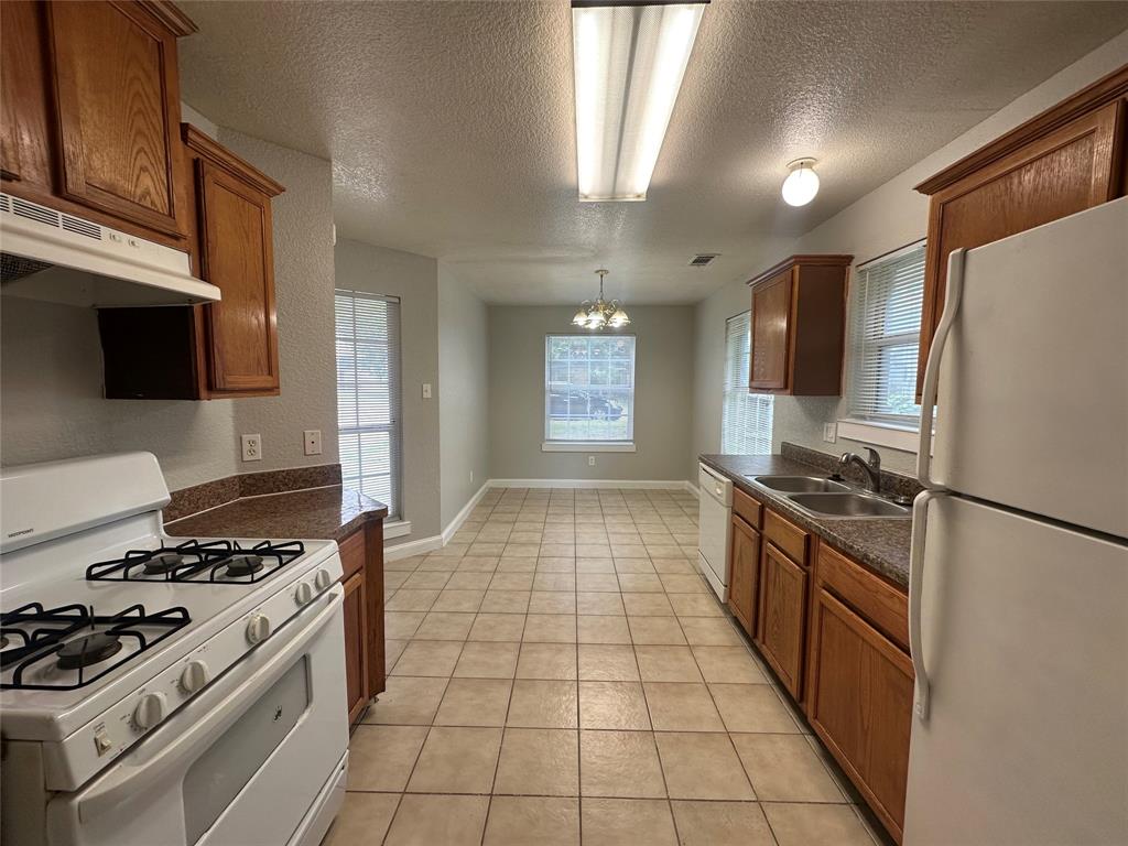 4147 Gladewater Road Dallas, TX 75216 - Photo 8 of 31 a kitchen with a stove a refrigerator and a sink