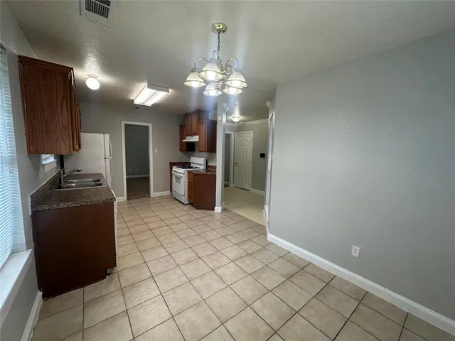 a kitchen with stainless steel appliances granite countertop a stove a refrigerator a sink dishwasher and a refrigerator