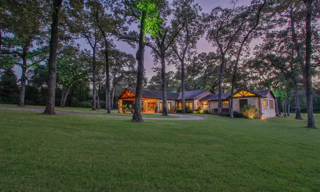 a view of a house with a big yard and large trees