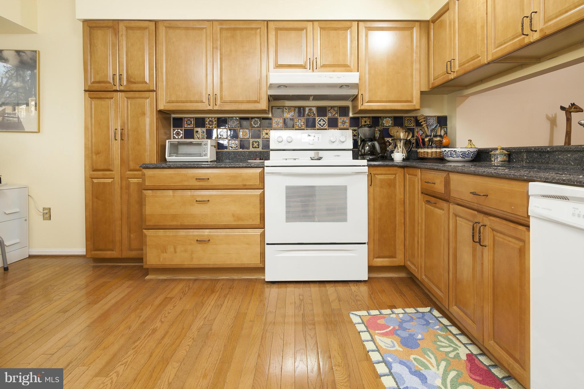 2005 Lyttonsville Road Silver Spring, MD 20910 - Photo 9 of 16 a kitchen with granite countertop wooden cabinets and white appliances