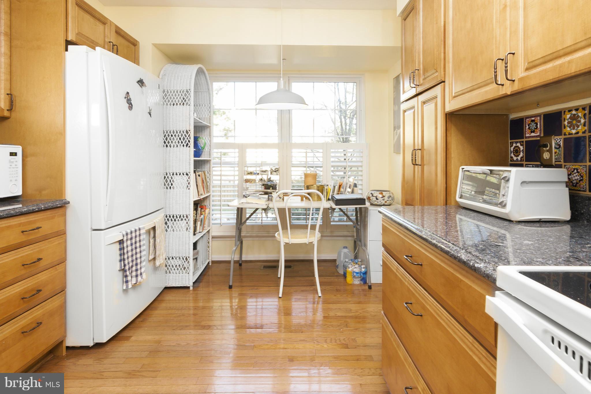 2005 Lyttonsville Road Silver Spring, MD 20910 - Photo 10 of 16 a dining hall with stainless steel appliances granite countertop a stove a sink dishwasher and white cabinets with wooden floor