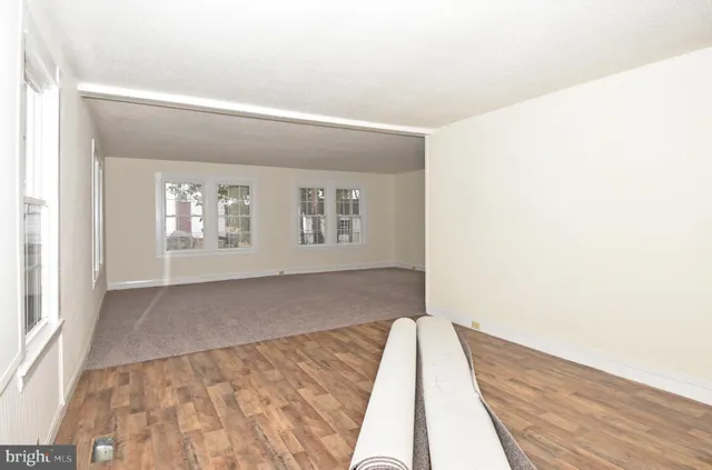 a view of a bedroom with wooden floor and windows
