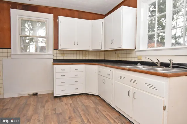 a kitchen with granite countertop white cabinets and white appliances