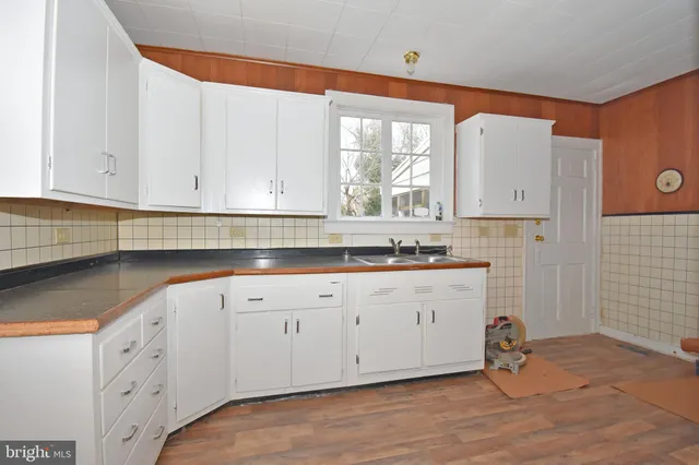 a kitchen with granite countertop white cabinets and white appliances