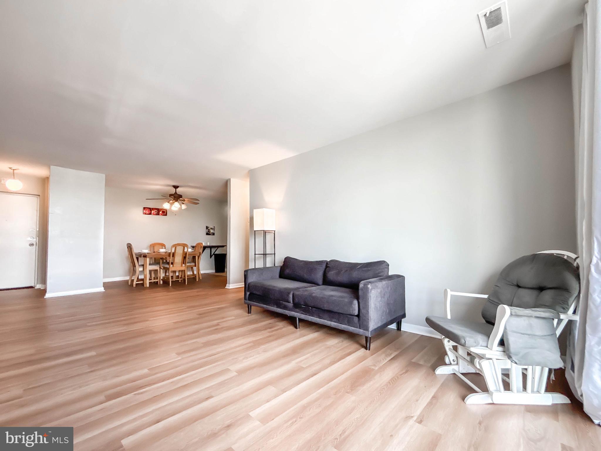 130 Slade Avenue, Unit 414 Baltimore, MD 21208 - Photo 2 of 48 a living room with furniture and a wooden floor