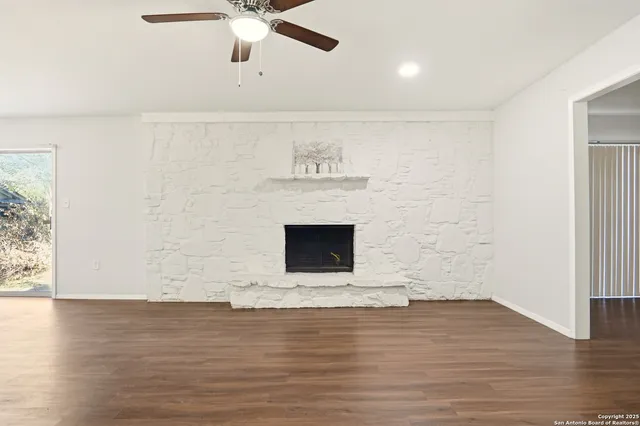 a view of a livingroom with wooden floor and a fireplace