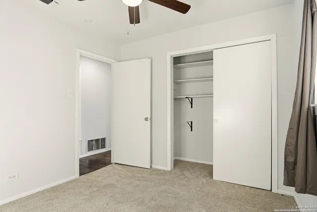 a view of an empty room with a ceiling fan