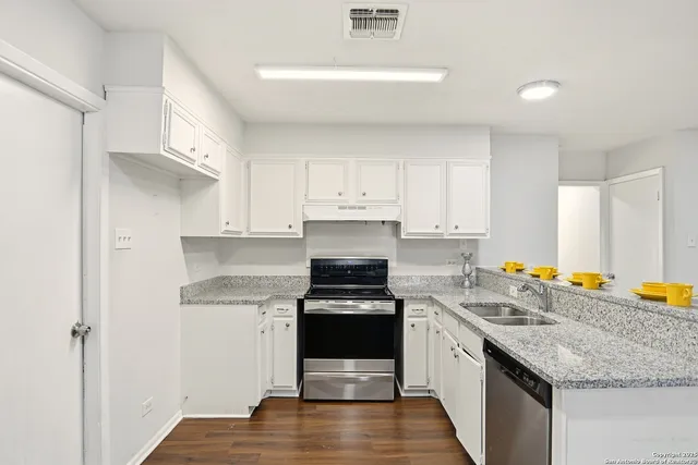 a kitchen with a sink stove and cabinets