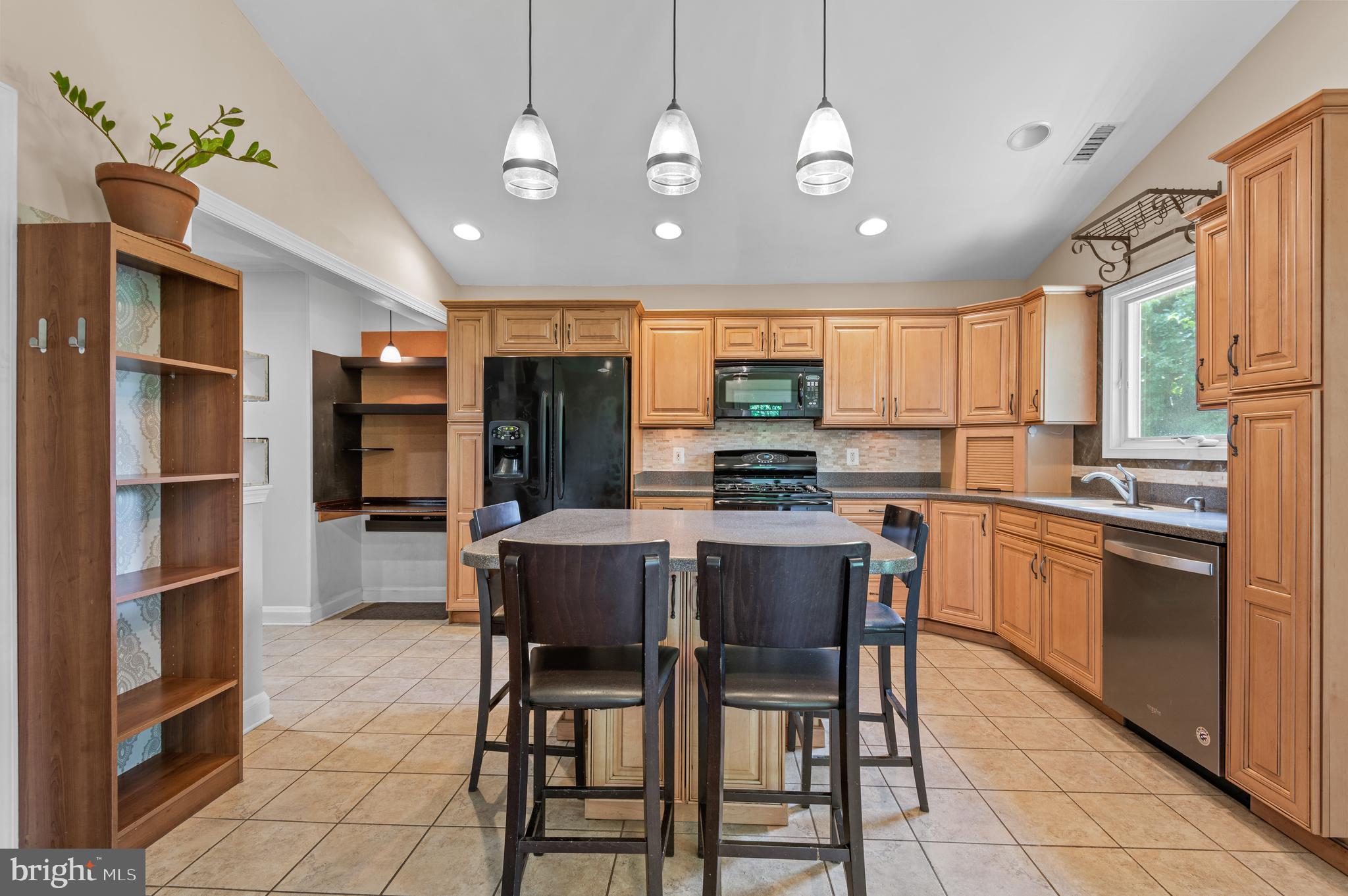 312 Whitaker Mill Road Fallston, MD 21047 - Photo 12 of 57 a kitchen with stainless steel appliances kitchen island granite countertop a refrigerator a stove a sink dishwasher and a dining table with wooden floor