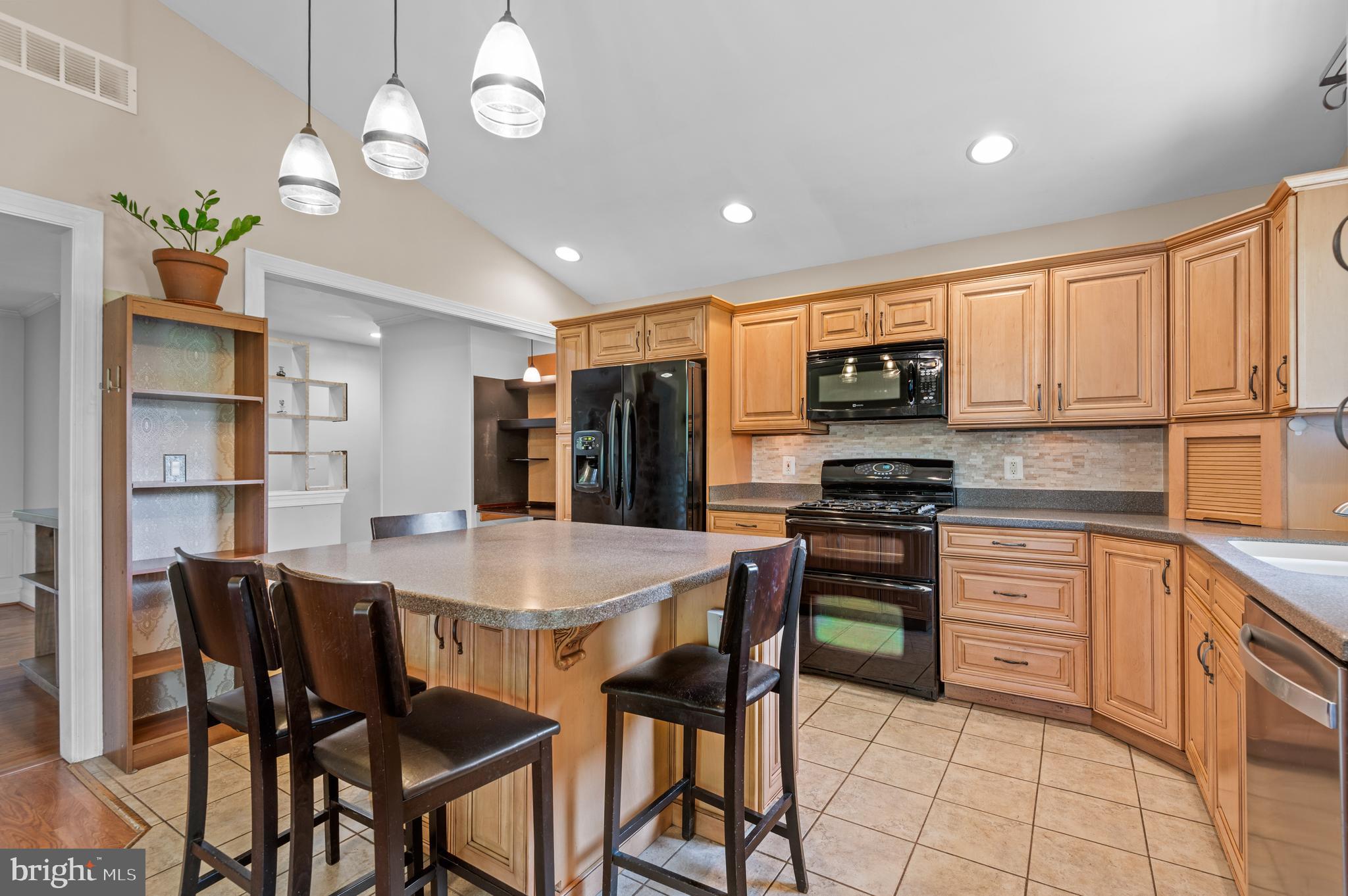 312 Whitaker Mill Road Fallston, MD 21047 - Photo 8 of 57 a kitchen with stainless steel appliances granite countertop a stove a refrigerator a microwave oven with white cabinets and wooden floor