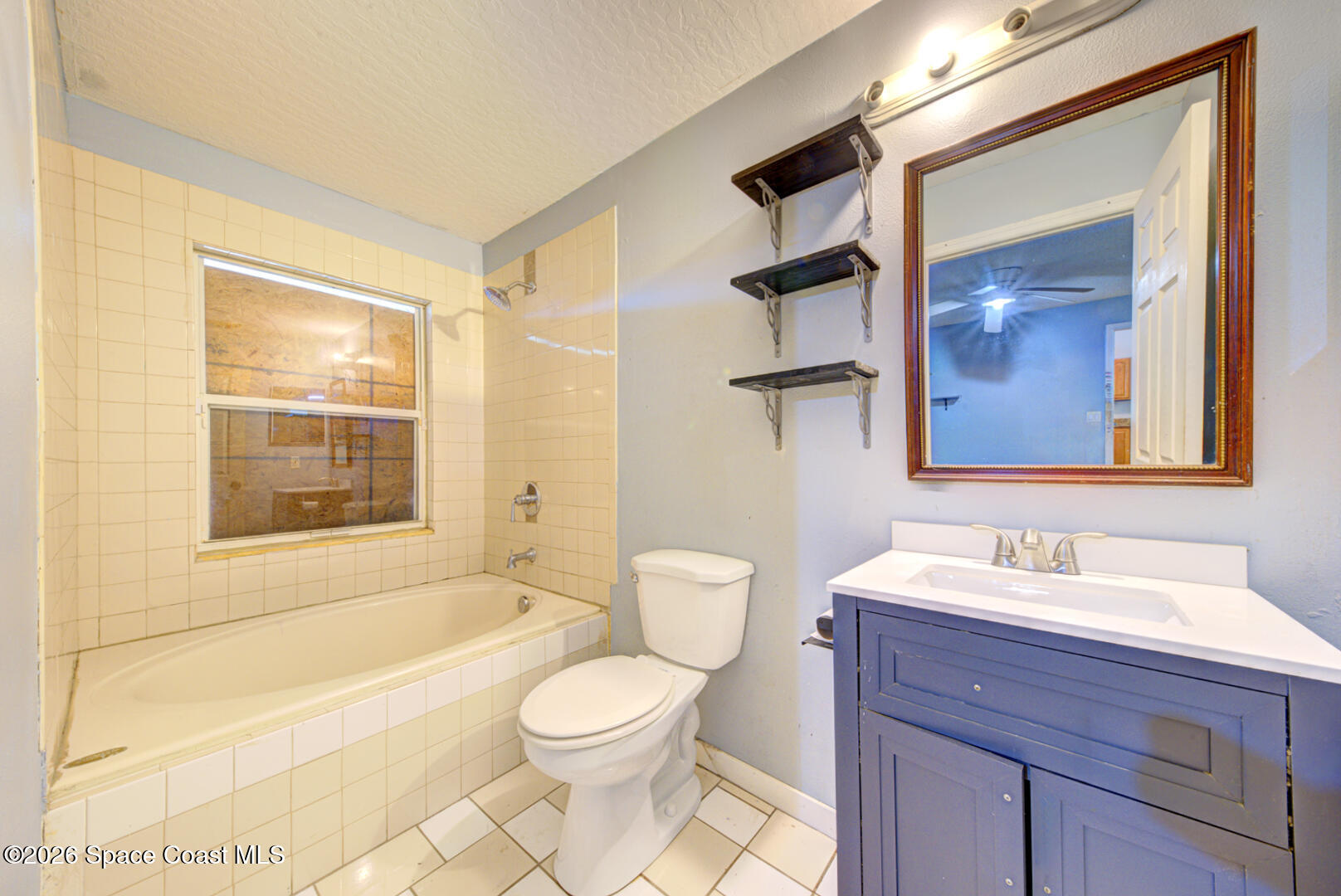 1090 Castile Road Southeast Palm Bay, FL 32909 - Photo 12 of 23 a bathroom with a toilet a sink and a large mirror
