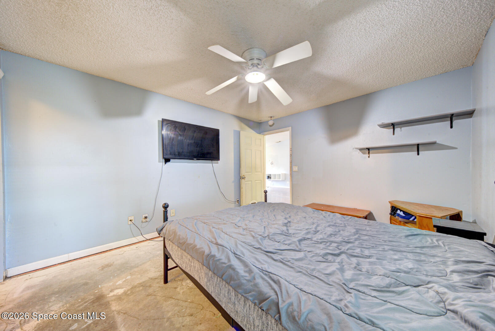 1090 Castile Road Southeast Palm Bay, FL 32909 - Photo 13 of 23 a bedroom with a bed and a flat tv screen on dresser