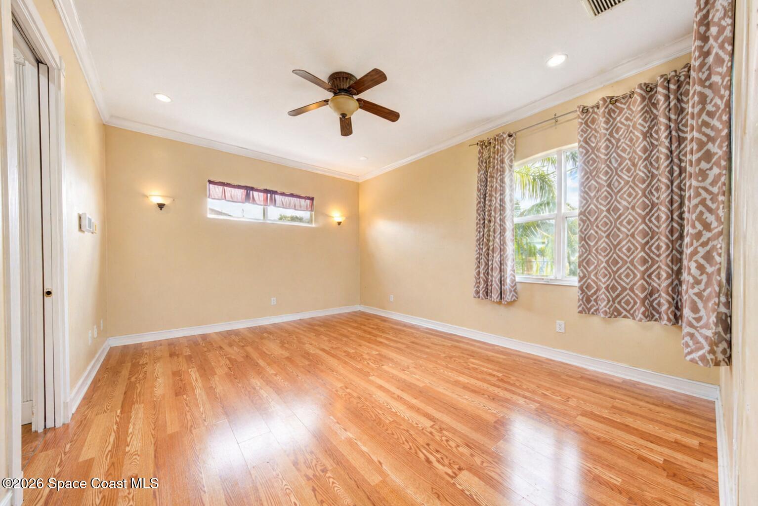 1090 Castile Road Southeast Palm Bay, FL 32909 - Photo 15 of 23 a view of empty room with wooden floor and fan
