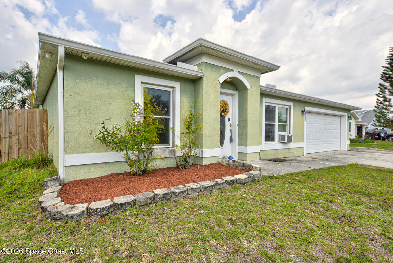 1090 Castile Road Southeast Palm Bay, FL 32909 - Photo 2 of 23 a front view of a house with garden