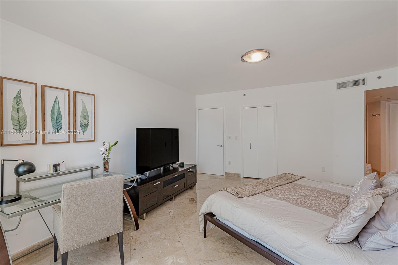 18911 Collins Avenue, Unit 3402 Sunny Isles Beach, FL 33160 - Photo 15 of 27 a bedroom with a bed and a flat screen tv