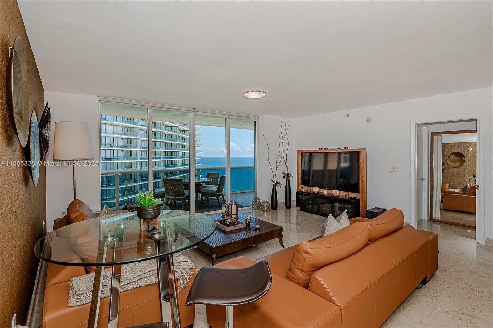 18911 Collins Avenue, Unit 3402 Sunny Isles Beach, FL 33160 - Photo 2 of 27 a living room with furniture and a flat screen tv