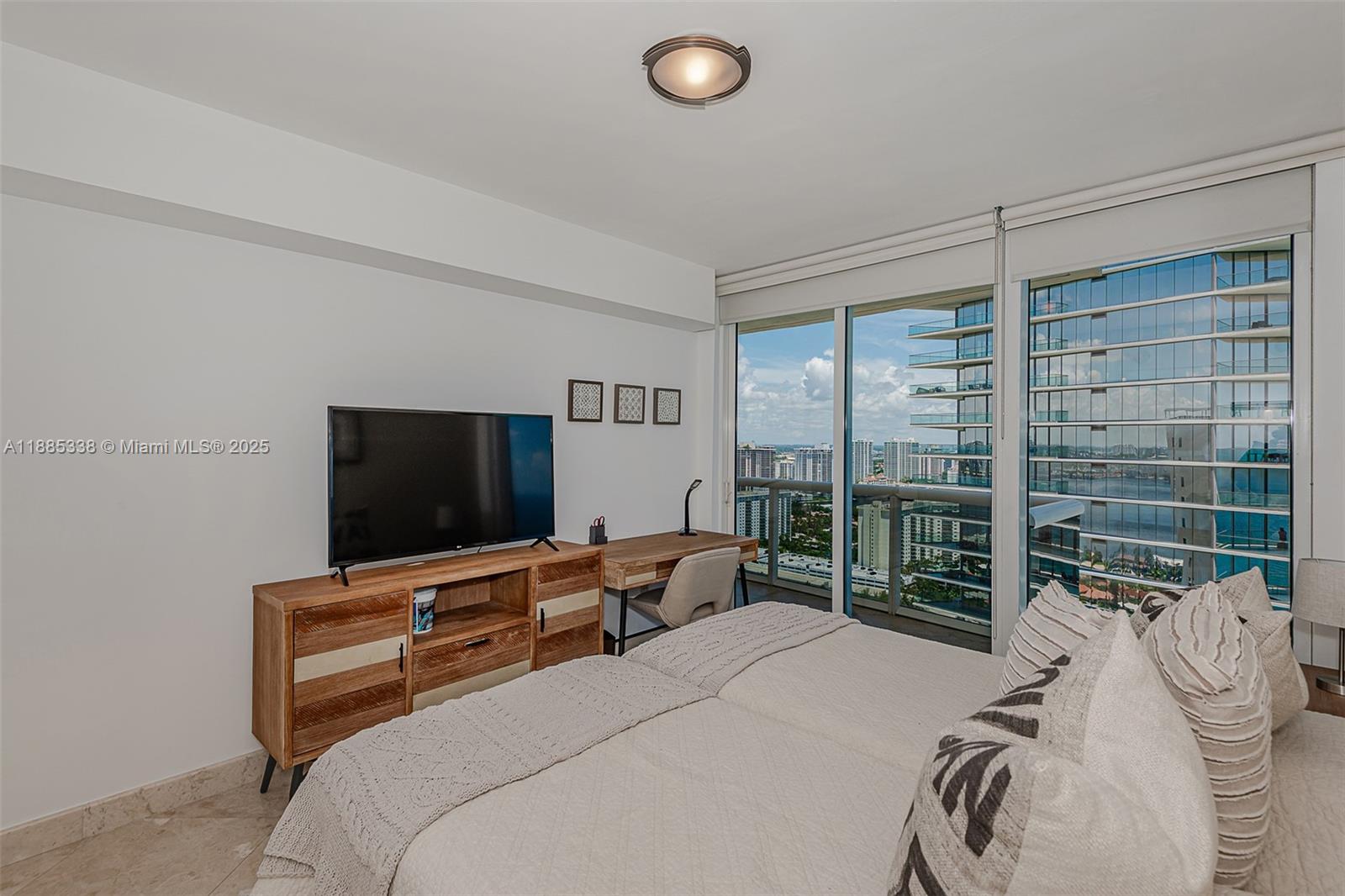 18911 Collins Avenue, Unit 3402 Sunny Isles Beach, FL 33160 - Photo 21 of 27 a bedroom with a bed and glass window