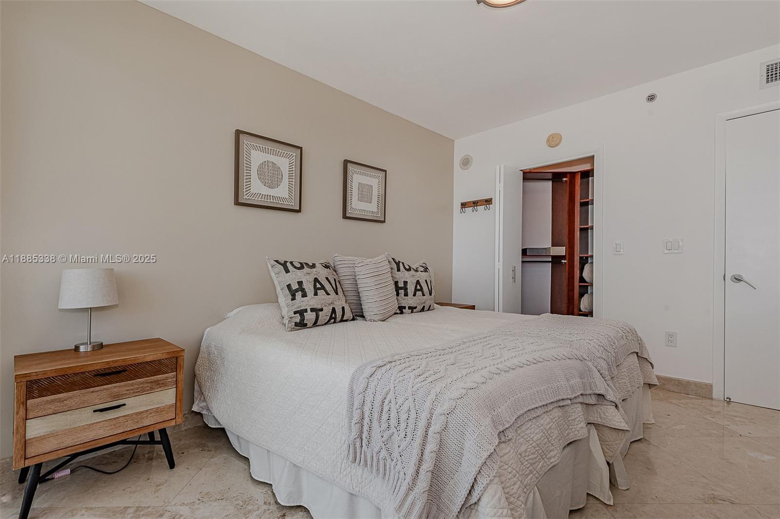 18911 Collins Avenue, Unit 3402 Sunny Isles Beach, FL 33160 - Photo 22 of 27 a bedroom with a bed and a lamp