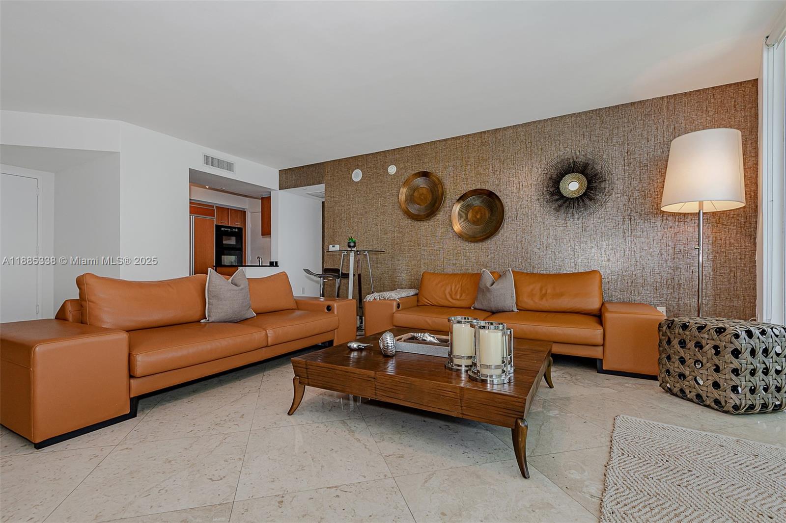 18911 Collins Avenue, Unit 3402 Sunny Isles Beach, FL 33160 - Photo 4 of 27 a living room with furniture and a lamp