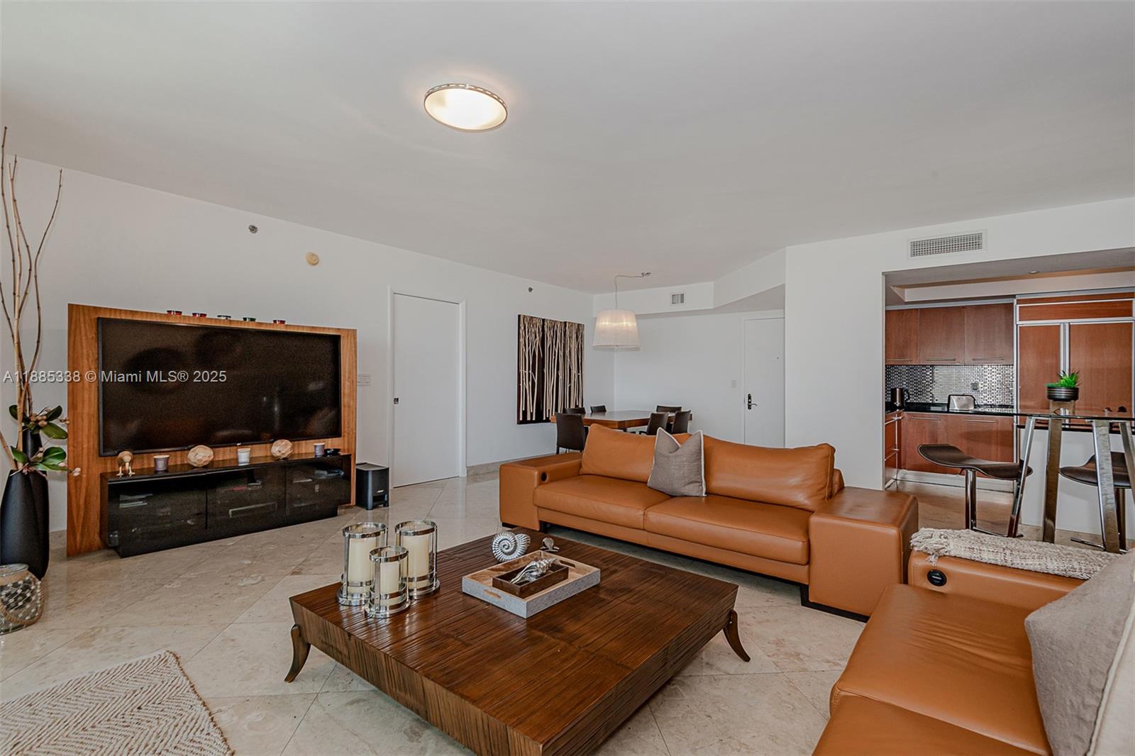 18911 Collins Avenue, Unit 3402 Sunny Isles Beach, FL 33160 - Photo 5 of 27 a living room with furniture and a flat screen tv