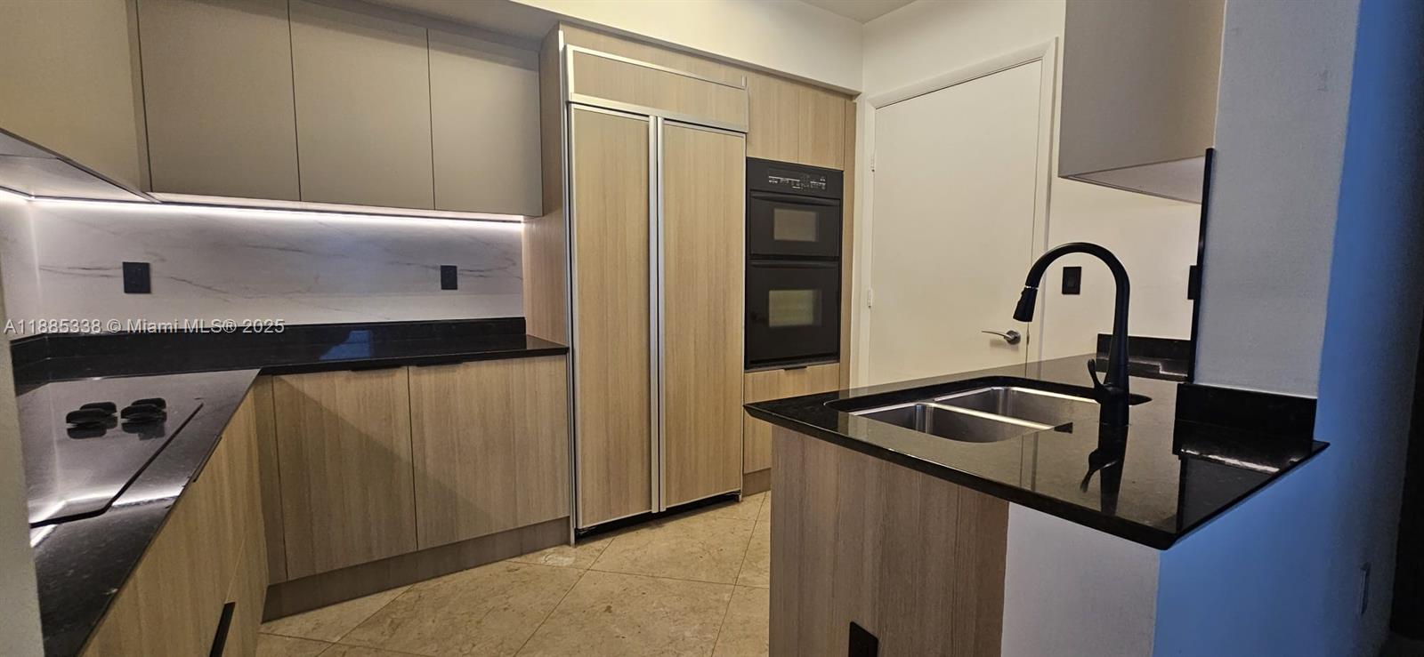 18911 Collins Avenue, Unit 3402 Sunny Isles Beach, FL 33160 - Photo 9 of 27 a kitchen with a sink and a refrigerator