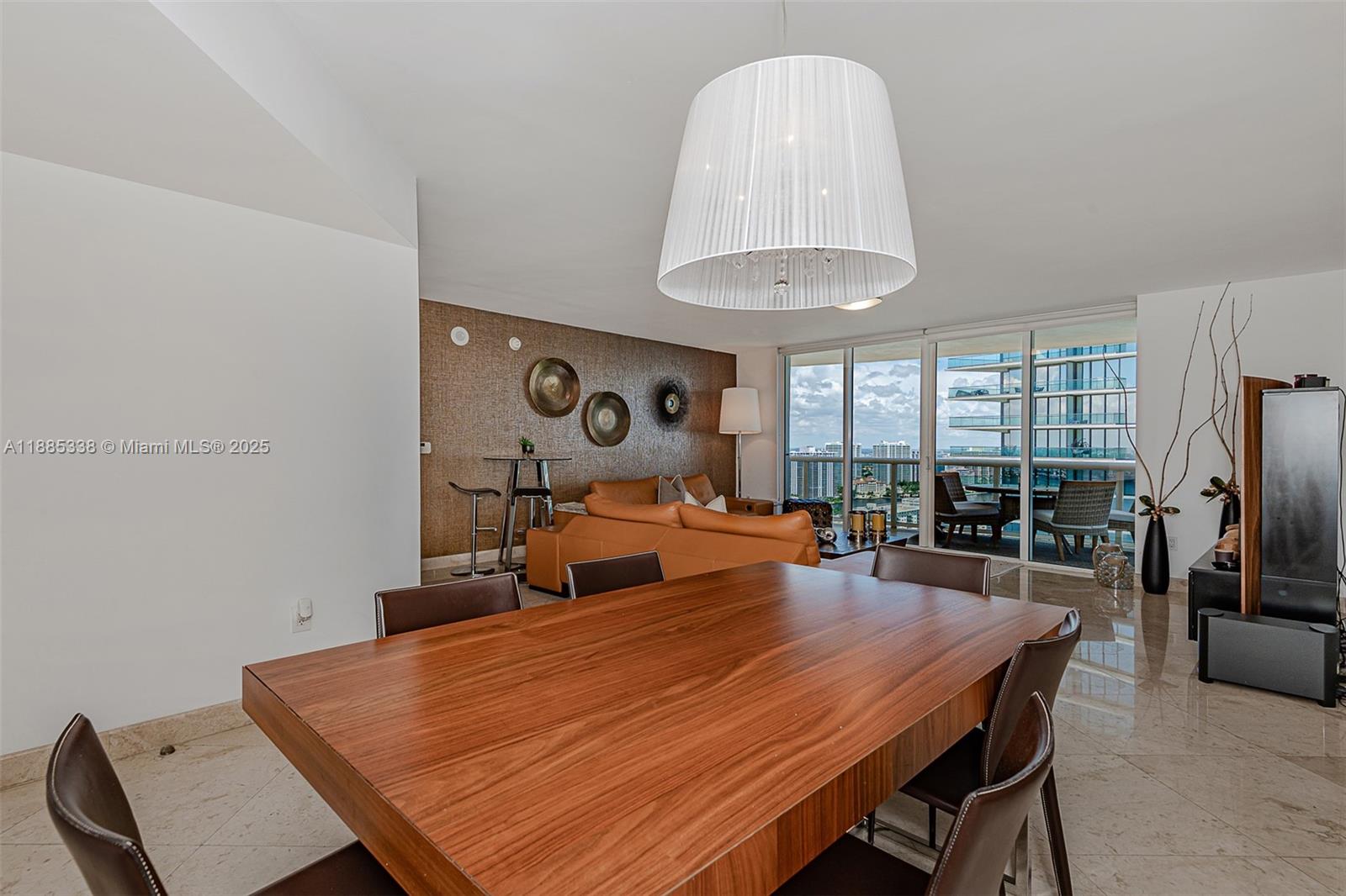 18911 Collins Avenue, Unit 3402 Sunny Isles Beach, FL 33160 - Photo 10 of 27 a dining room with furniture a chandelier and wooden floor