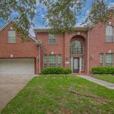 front view of a brick house with a yard