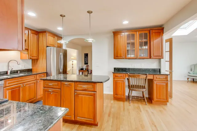 a kitchen with stainless steel appliances granite countertop a sink and a wooden cabinets