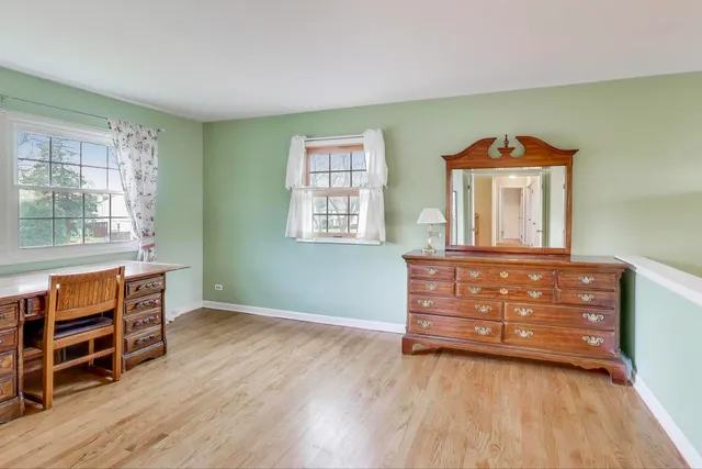 a view of room with wooden floor and furniture