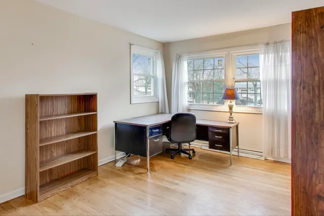 a view of a workspace with furniture and a window