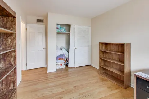 an empty room with wooden floor and closet