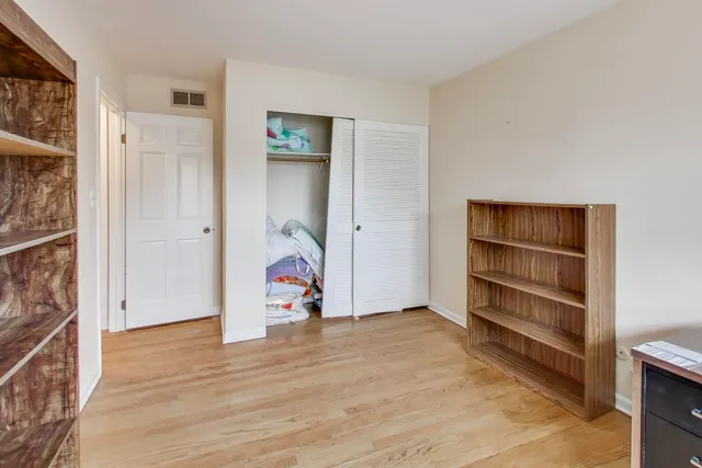 an empty room with wooden floor and closet