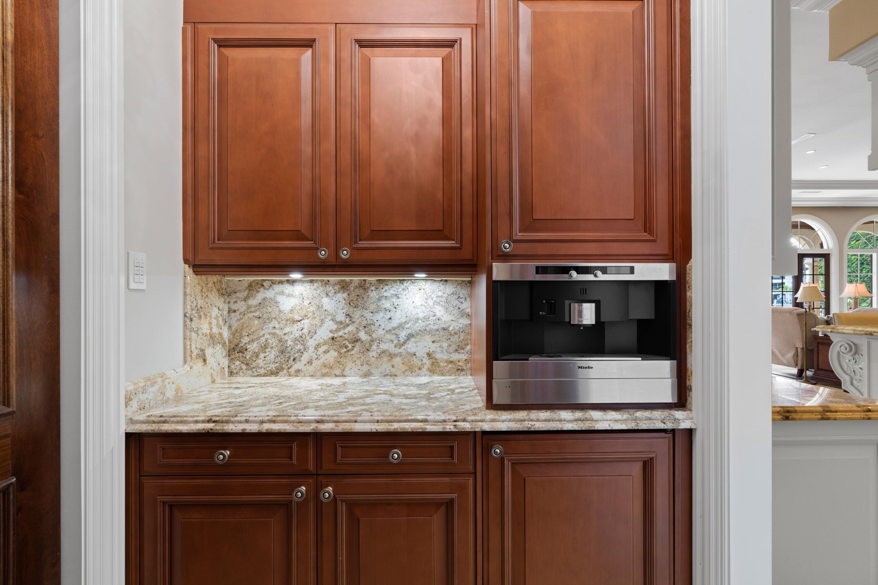 166 Alexander Palm Road Boca Raton, FL 33432 - Photo 44 of 122 a kitchen with granite countertop wooden cabinets and a sink