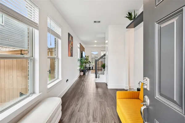 a living room with furniture with kitchen view and a chandelier