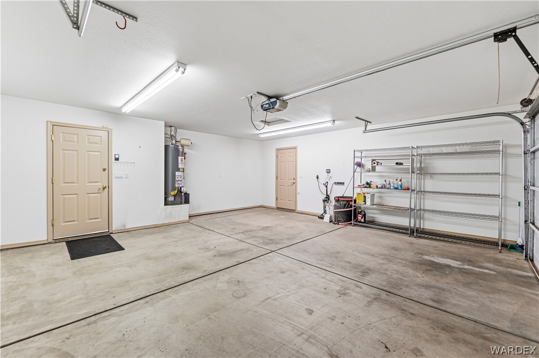 3973 Prairie View Drive Kingman, AZ 86409 - Photo 33 of 34 The property includes a spacious garage with a light-colored interior, concrete flooring, and overhead lighting
