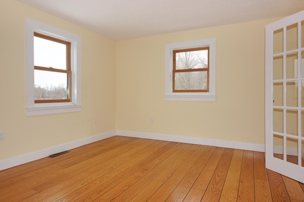 24 Prospect Hill Road Harvard, MA 01451 - Photo 16 of 28 an empty room with wooden floor and windows