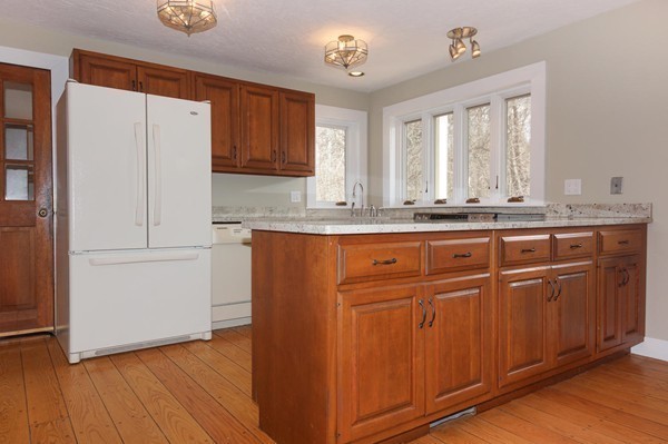 24 Prospect Hill Road Harvard, MA 01451 - Photo 5 of 28 a kitchen with granite countertop wooden cabinets and white appliances