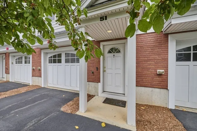 a front view of a house with a tree