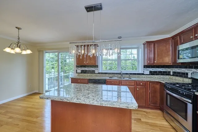 a kitchen with stainless steel appliances granite countertop a stove a sink and a microwave