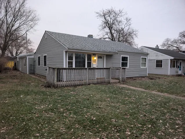 a view of a house with a yard and large tree