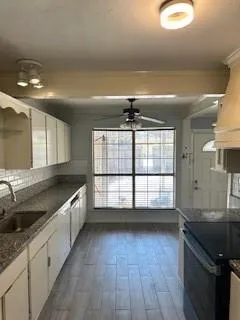 a large kitchen with a large counter space a sink and cabinets