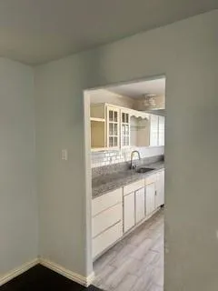 a bathroom with granite countertop a sink and a mirror