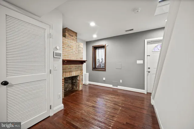 an empty room with wooden floor and fireplace