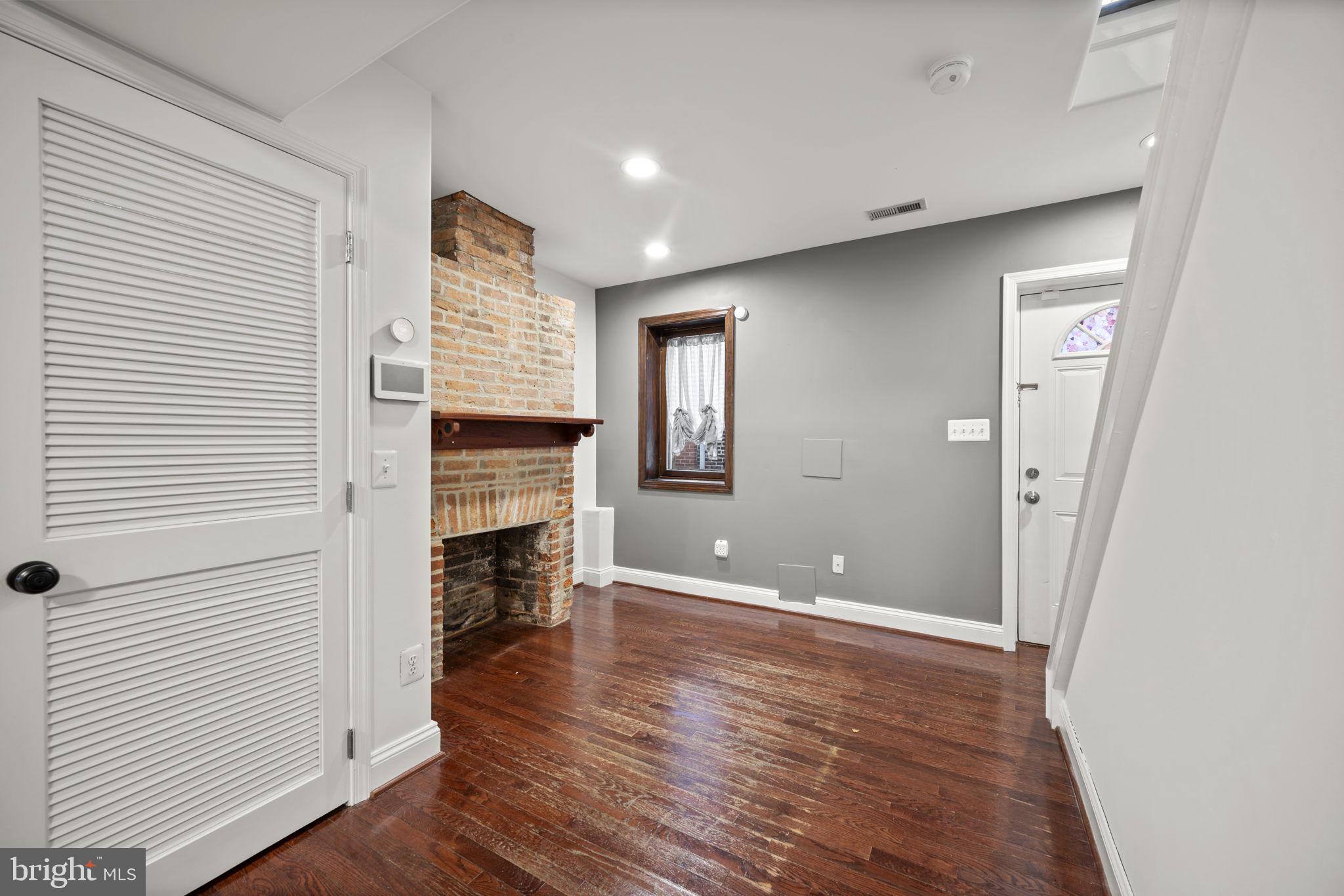 413 Griffin Court Baltimore, MD 21231 - Photo 11 of 37 an empty room with wooden floor and fireplace