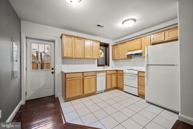 a kitchen with a refrigerator sink and cabinets
