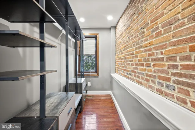 a hallway with a large window and wooden floor