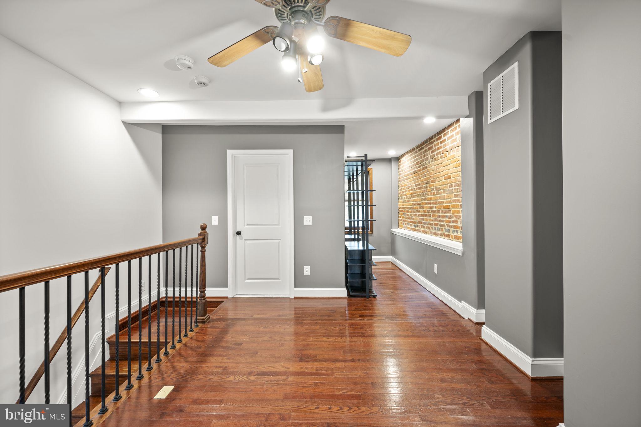 413 Griffin Court Baltimore, MD 21231 - Photo 27 of 37 a view of empty room with wooden floor and fan