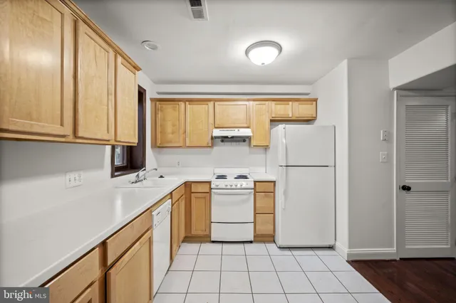 a kitchen with a stove a refrigerator and a sink