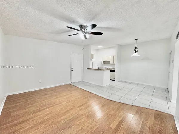 a view of empty room with wooden floor and windows